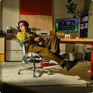 Person using a high-tech gaming chair in a modern office setting~scene
